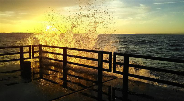 打ち寄せる波と夕日